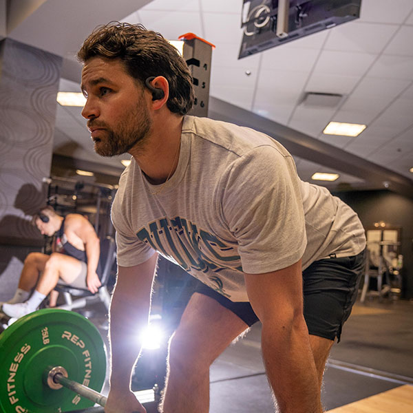 Young man lifting weights and looking in the mirror
