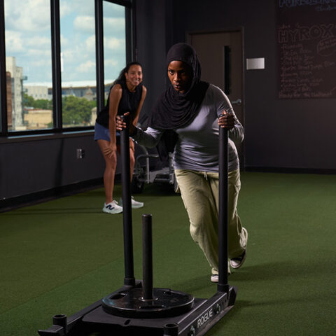 Girl pushing weights at gym and smiling