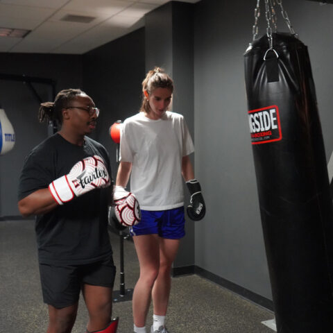 two people at a punching bag