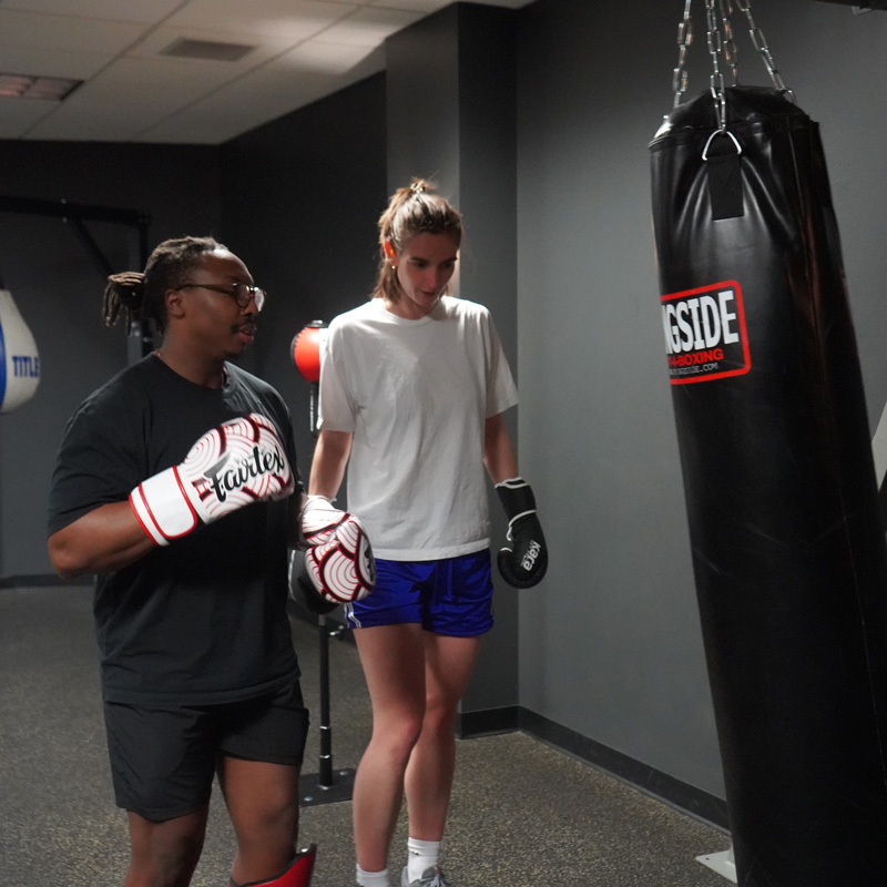 two people at a punching bag